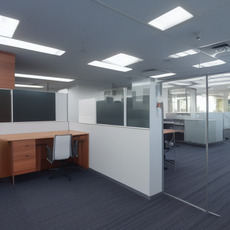 A large office with several monitors and chairs is clean and ready for work.