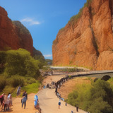 People walking on a path between two large mountains.