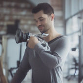 A man is holding a pair of weightlifting weights.