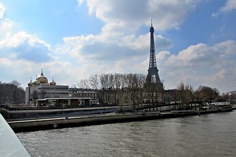 A boat travels through the water near the Eiffel Tower.