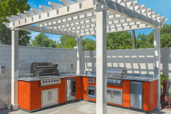 Outdoor kitchen with stainless steel grills and orange cabinets under a white pergola.
