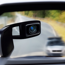 A view through a side mirror of a car driving on the road.