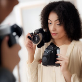 The woman is holding two cameras.